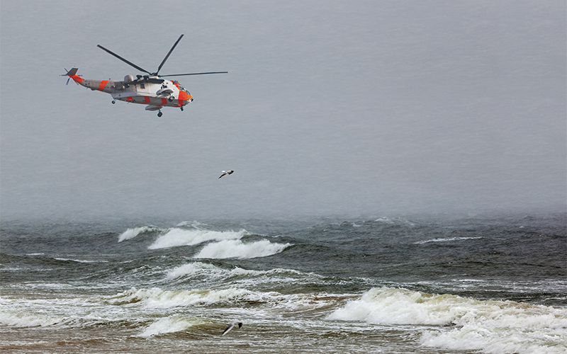 Rescue helicopter flying above sea