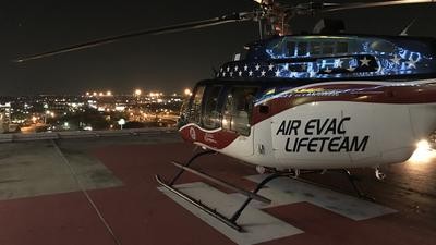 Air Evac Lifeteam helicopter on roof helipad at nighttime