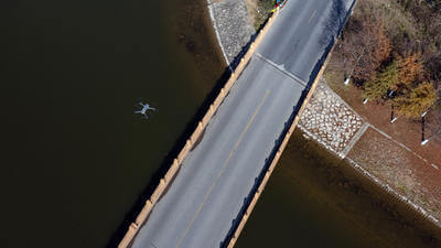 Image of drone flying over bridge from above