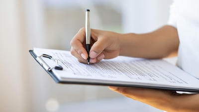 Holding clipboard and a pen in office