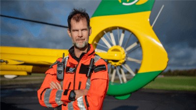 Hampshire and Isle of Wight Air Ambulance worker stood in front of aircraft