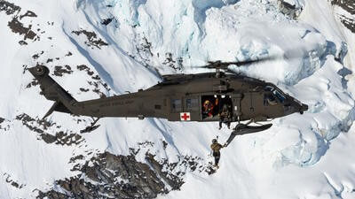 Rescue helicopter in snowy mountain range