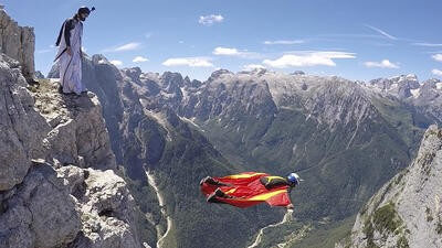 Paraglider diving in mountains