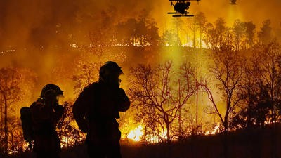 Firefighters using drones next to wildfire
