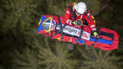 Paramedic hoisting up patient