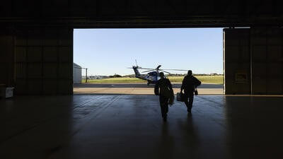 Helicopter pilots heading towards helicopter