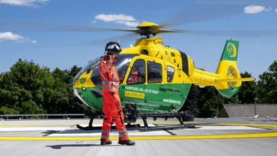 Crewmember does a thumbs-up in front of HIOWAA air ambulance helicopter