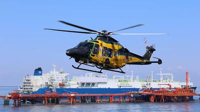 Yellow helicopter flying above sea