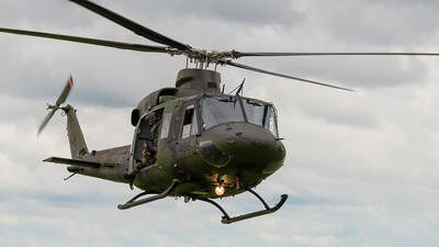 Green military helicopter flying in sky