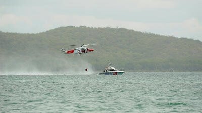 Helicopter picking up water by boat