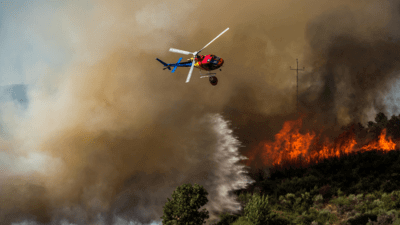 Helicopter flying over burning field