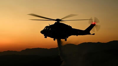 Helicopter dropping fire retardant at dusk