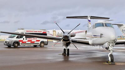 Plane parked on runway next to van