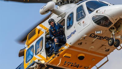 Rescue team peering out of helicopter