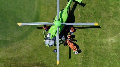 Green helicopter parked on grass