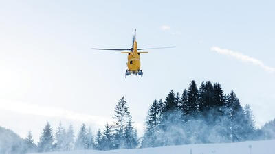 Helicopter flying over snow