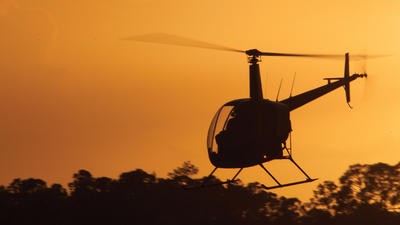 helicopter flying during sunset