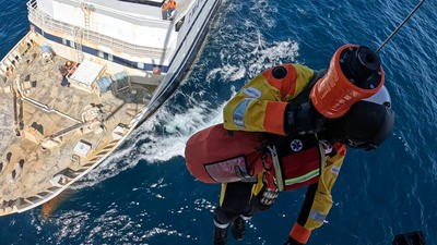 Paramedic hoisting out of helicopter