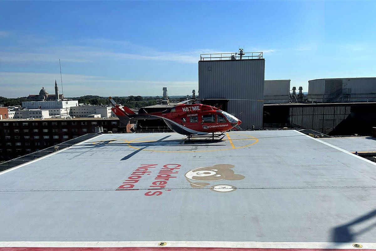 Red helicopter parked on top of building