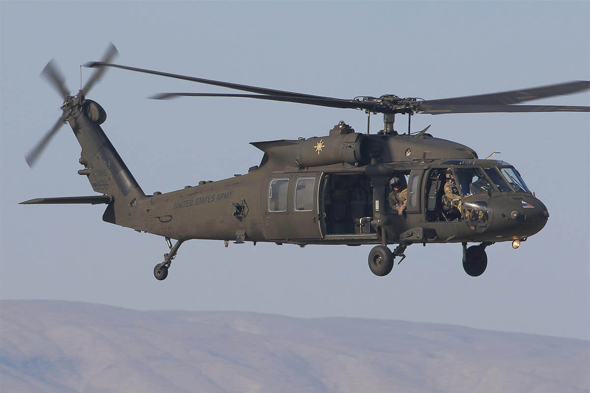 Green helicopter in sky