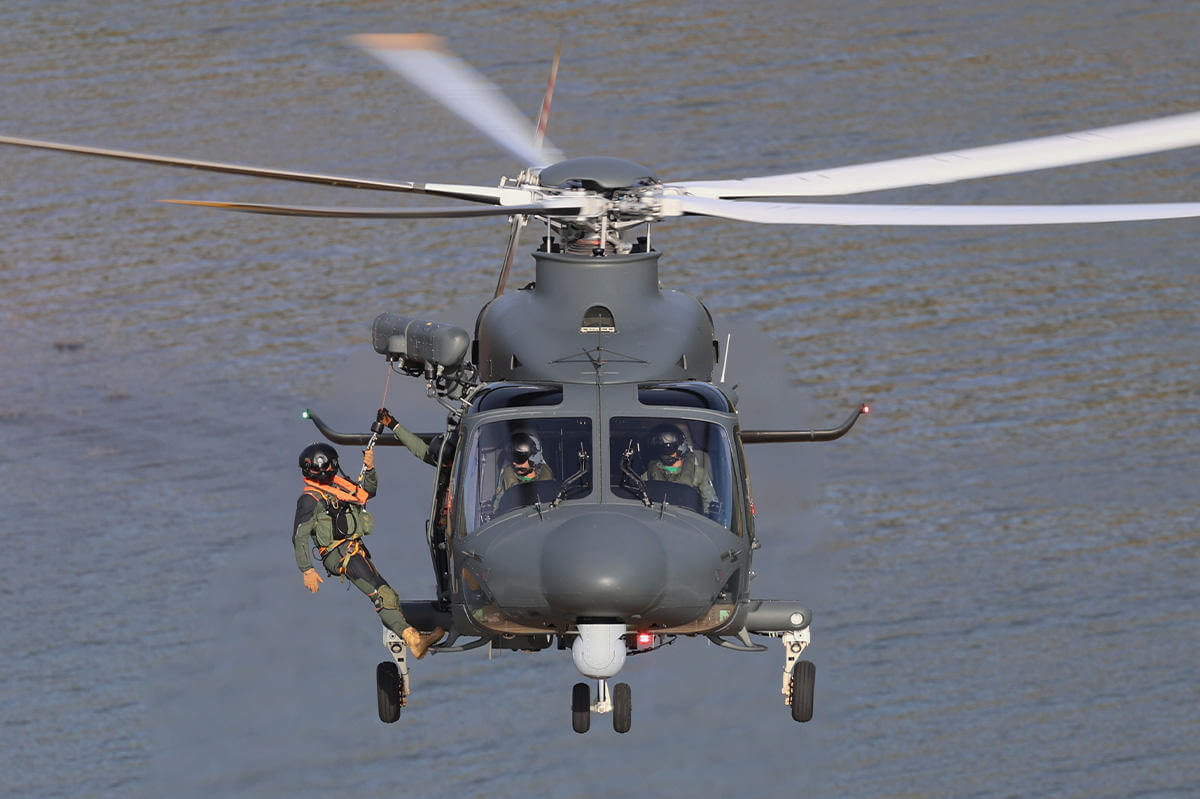 military personnel about to hoist from helicopter