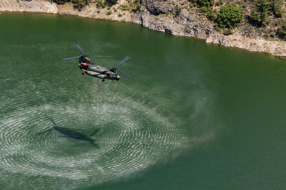 Helicopter picking up water for firefighting