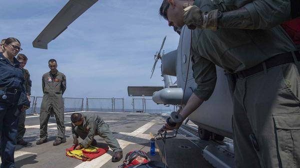 Naval Air Crewman 2nd Class Tanner Lessard, from Wales, Maine, instructs Sailors