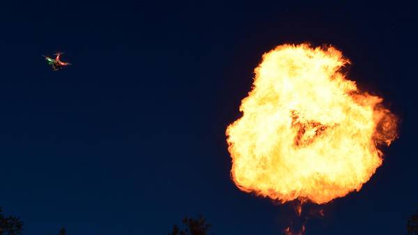 A drone flying next to a fireball