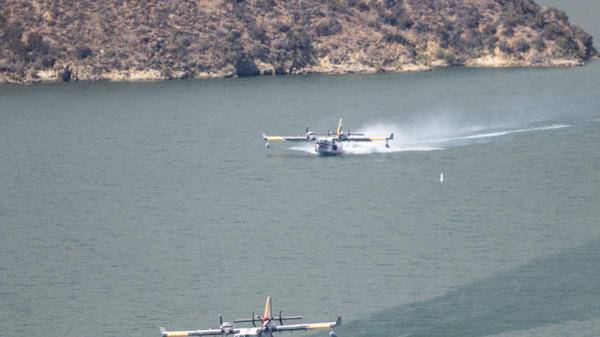canadair firefighting aircraft scooping from a lake