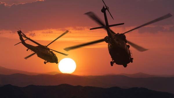 Helicopters flying into the sunset