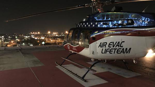 Air Evac Lifeteam helicopter on roof helipad at nighttime