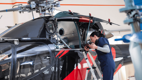Woman working on helicopter engine