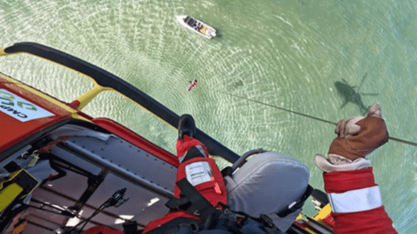 Air crew hoisting up patient from lake