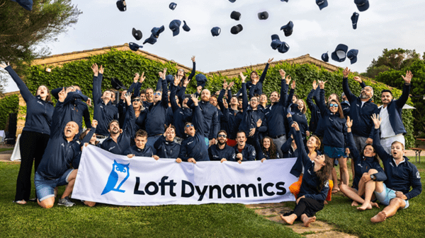 Loft dynamics graduation style photo, throwing caps in the air and holding banner