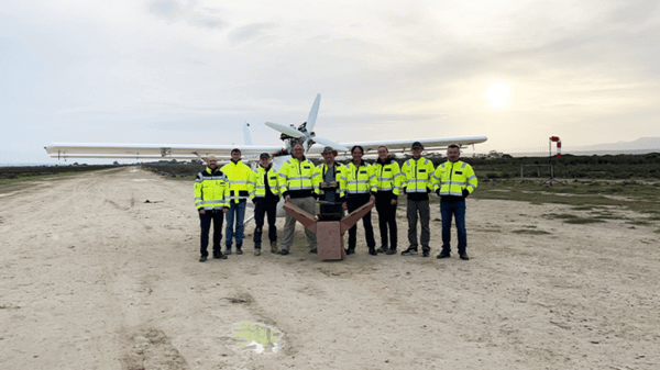 Workers posing in front of plane in high vis jackets