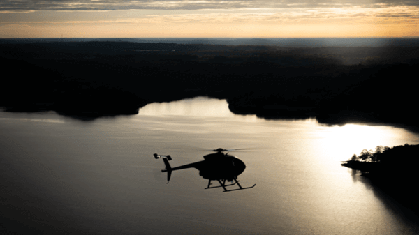 Police helicopter flying over lake at night