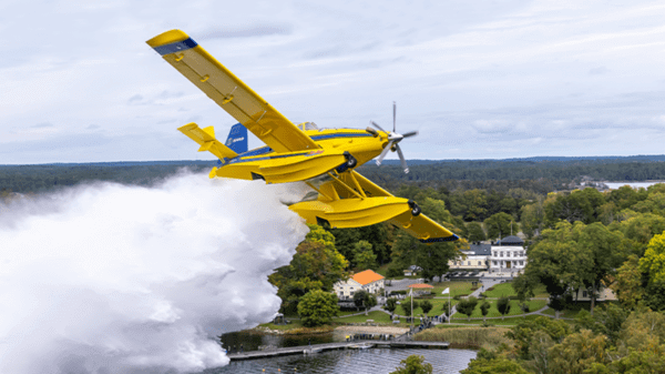 Yellow plane flying over river