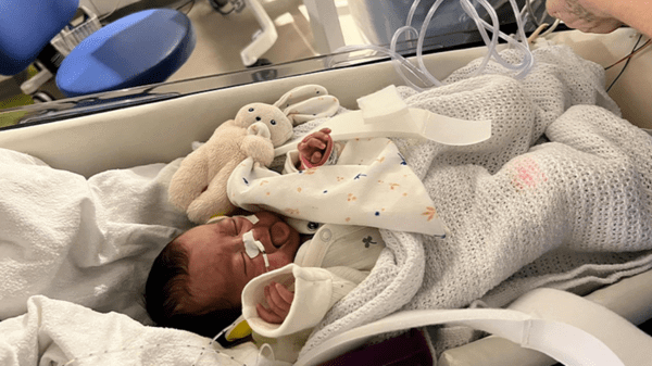 Baby crying in hospital bed