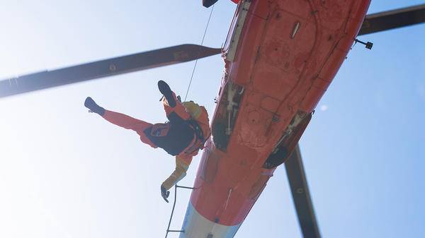 AirMed paramedic hoisting out of helicopter