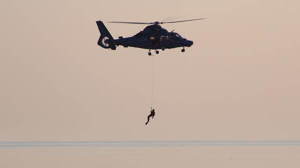 Paramedic hoisted out of helicopter above sea