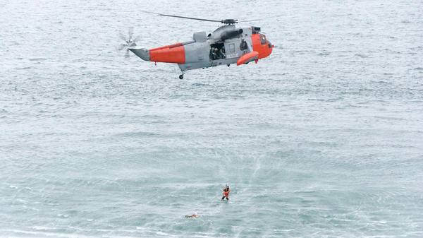Paramedic hoisted out of helicopter above sea