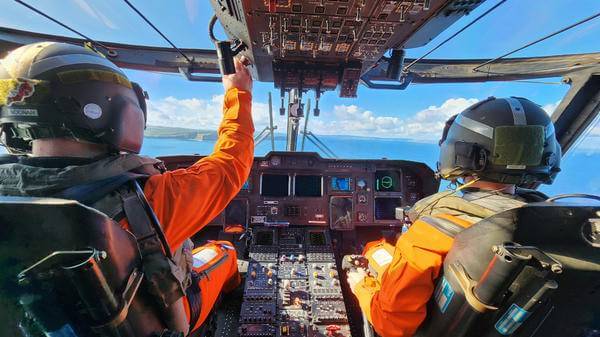 Airmed rescuers in cockpit of helicopter