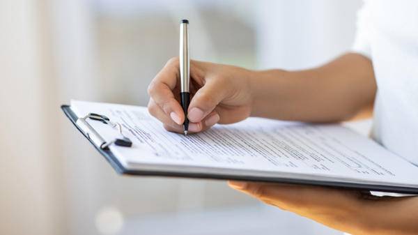 Holding clipboard and a pen in office