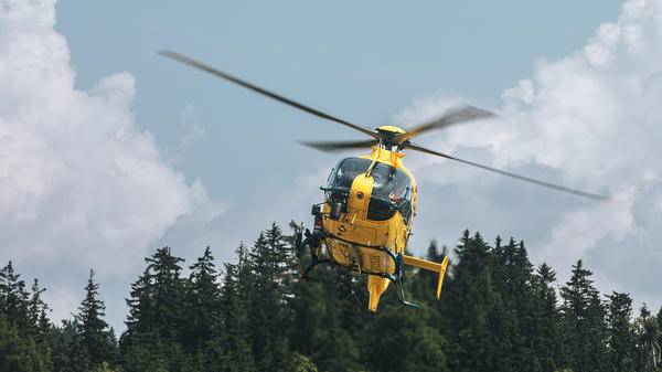 Yellow helicopter above forest