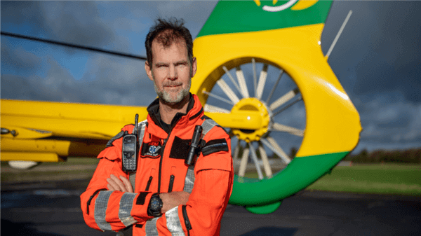 Hampshire and Isle of Wight Air Ambulance worker stood in front of aircraft