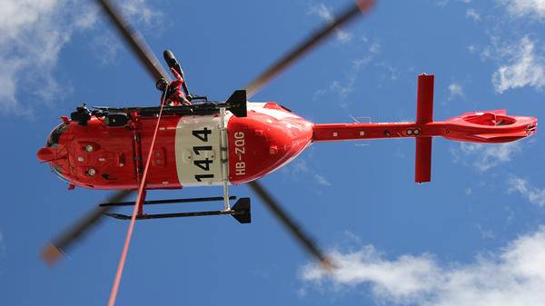 Man about to hoist himself out of helicopter