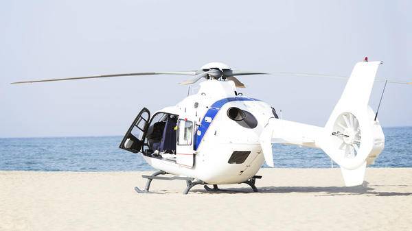 White helicopter parked on beach