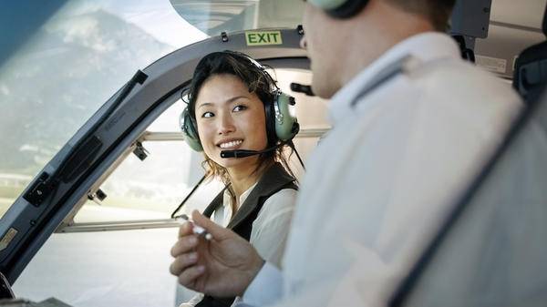 Helicopter pilot trainee smiling in cockpit