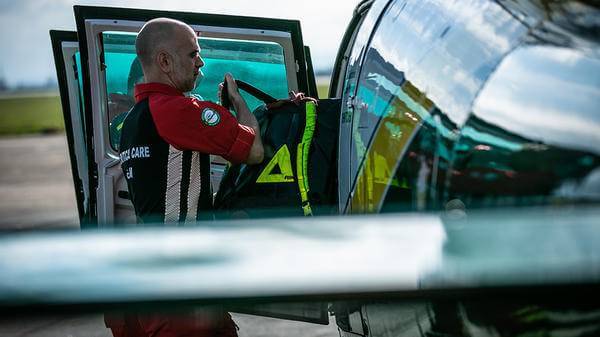 Paramedic putting equipment in helicopter 