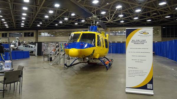 Yellow McDermott Aviation Group helicopter parked at event